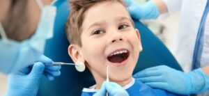 A smiling boy in dentists chair having his teeth examined